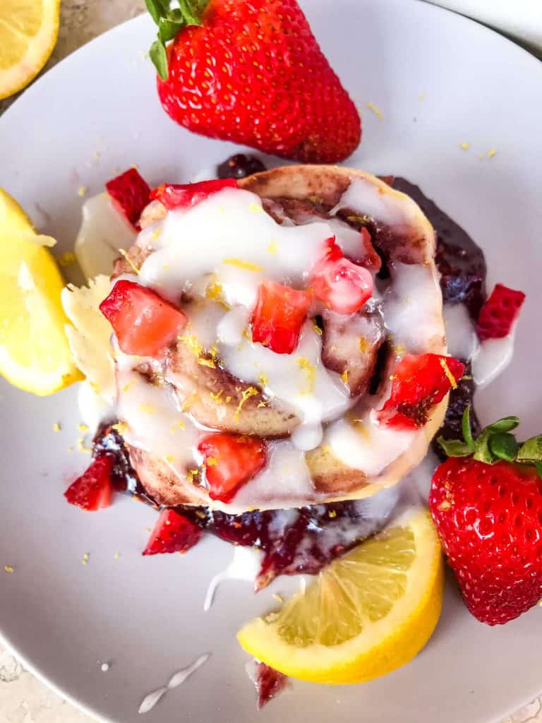 Homemade Strawberry Lemon Cinnamon Rolls with lemon icing glaze. Fresh strawberries and strawberry jam with cinnamon in a homemade dough. Bright spring and summer flavors for home breakfast and brunch baking recipes. #cinnamonrolls #strawberrylemon #bakingrecipes