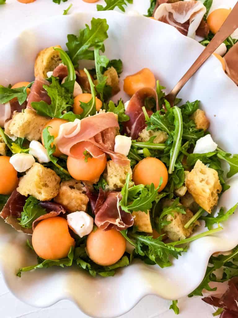 Close up of Prosciutto Melon Panzanella Salad with a spoon in it