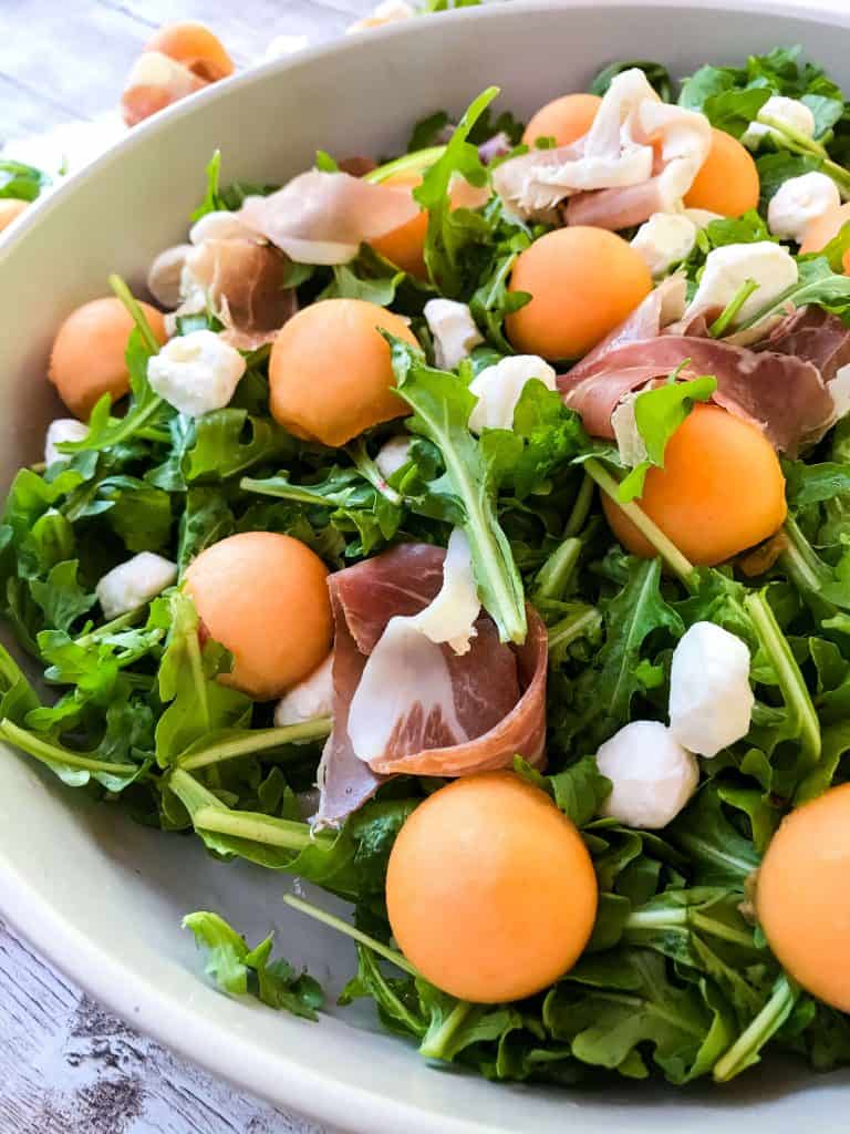 A close up of Prosciutto Melon Salad with Mozzarella and Arugula