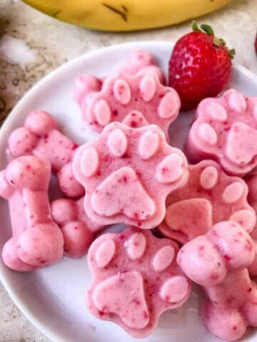 Close up of Frozen Strawberry Banana Dog Treats on a plate in a pile