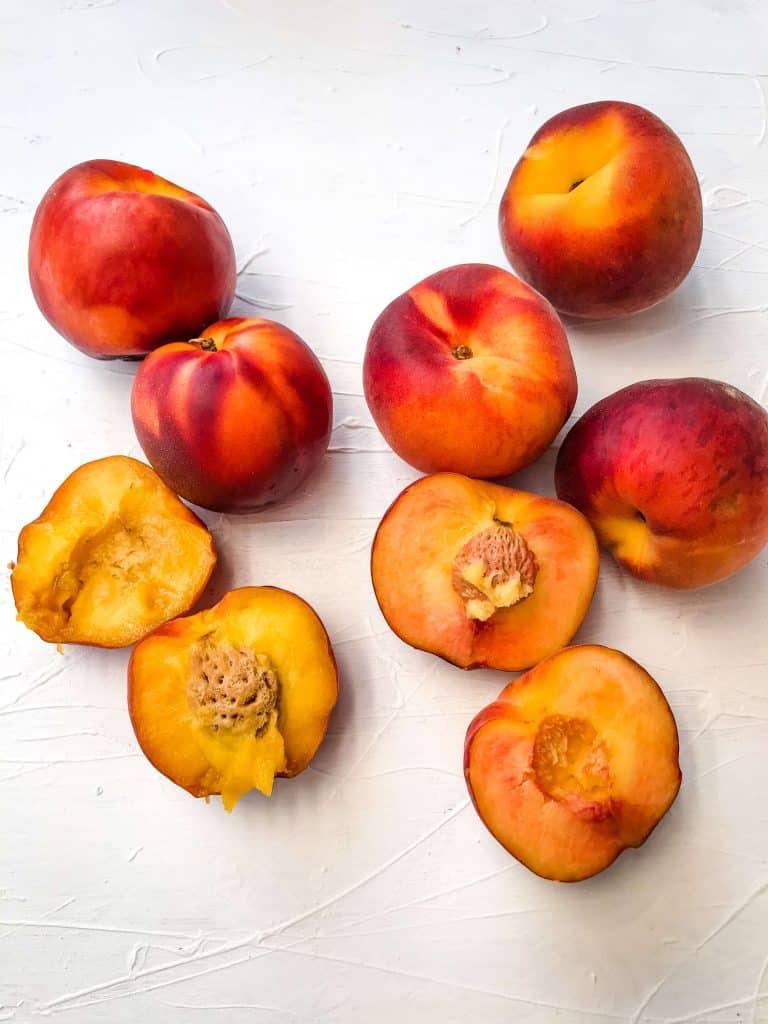 The Difference Between Peach and Nectarine with the fruit side by side on a white background 