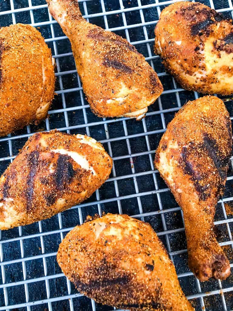 Pieces of Dry Rub Cajun Grilled Chicken Drumsticks on a wire rack