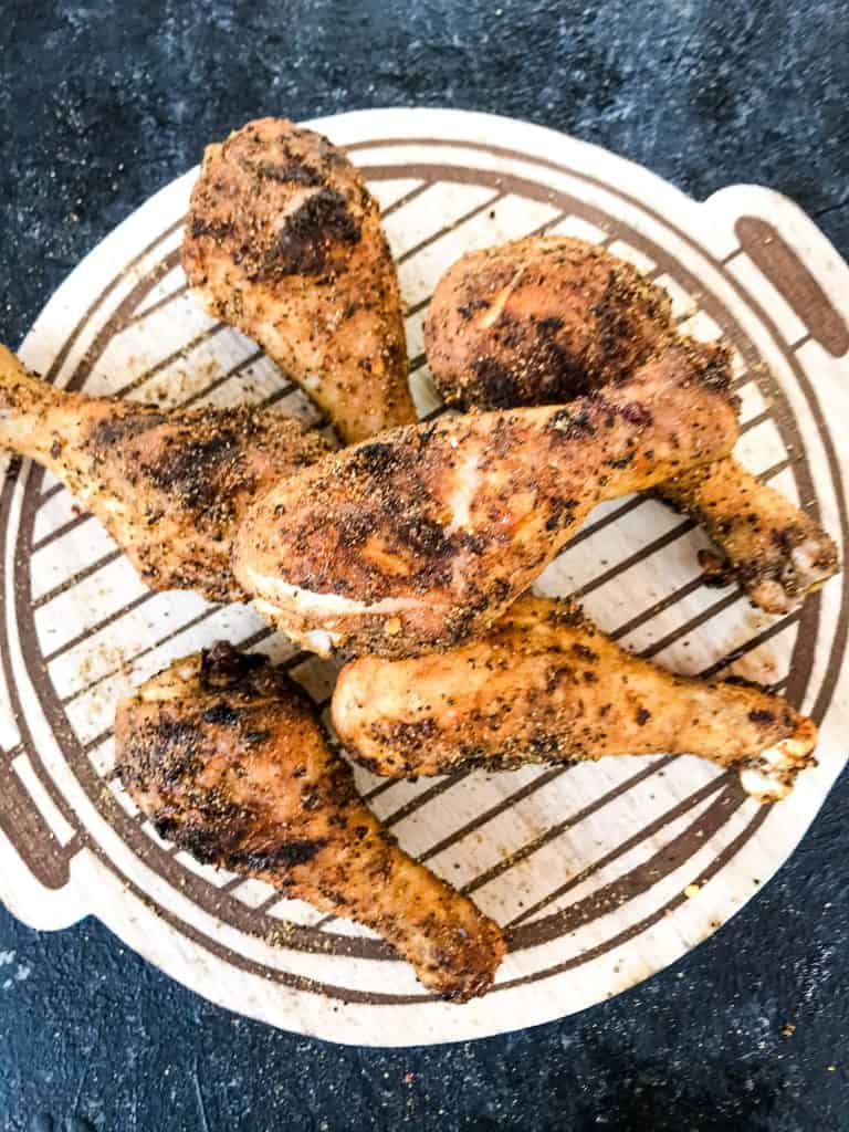 A pile of grilled Three Pepper Dry Rub for Chicken Drumsticks on a cutting board
