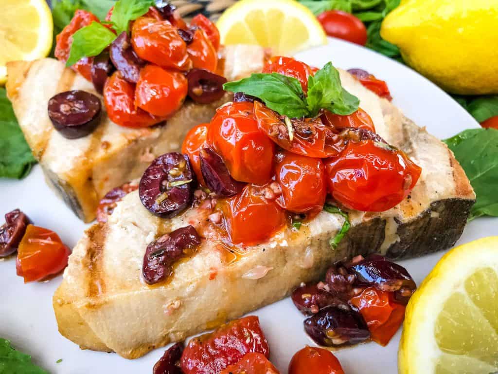 A close up of a piece of Grilled Swordfish Steaks with Tomato Olive Relish