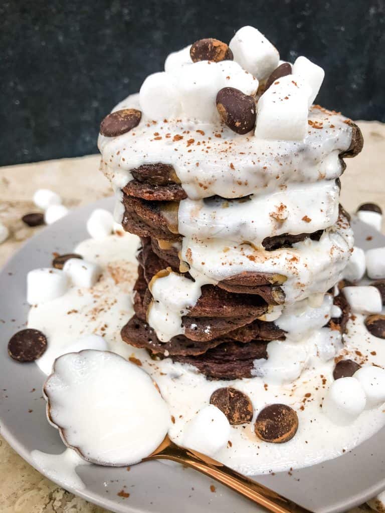 Stack of Hot Chocolate Pancakes on a plate with a copper spoon