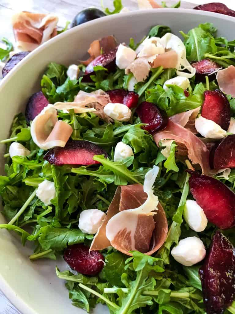 Close up of Prosciutto Plum Arugula Salad with Mozzarella