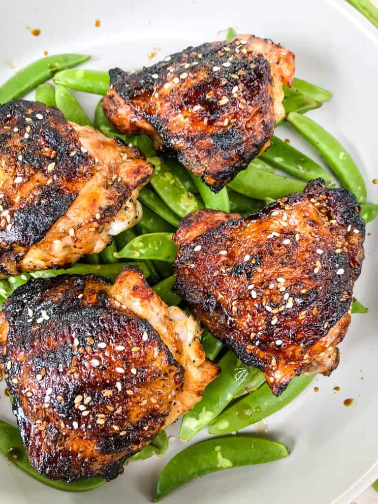 Sesame Soy Glazed Grilled Chicken Thighs are an easy grilled chicken recipe. BBQ bone in grilled chicken thighs are coated in a simple Asian glaze sauce. #grilledchickenthighs #glazedchickenrecipes #asianchickenrecipes