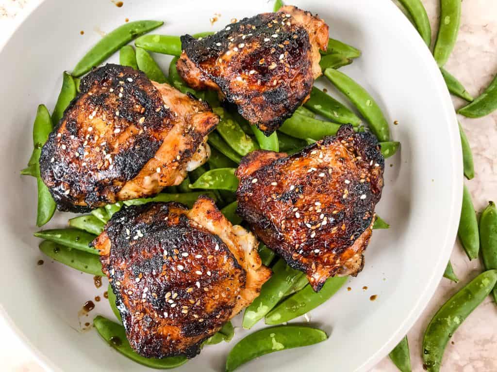 Sesame Soy Glazed Grilled Chicken Thighs are an easy grilled chicken recipe. BBQ bone in grilled chicken thighs are coated in a simple Asian glaze sauce. #grilledchickenthighs #glazedchickenrecipes #asianchickenrecipes