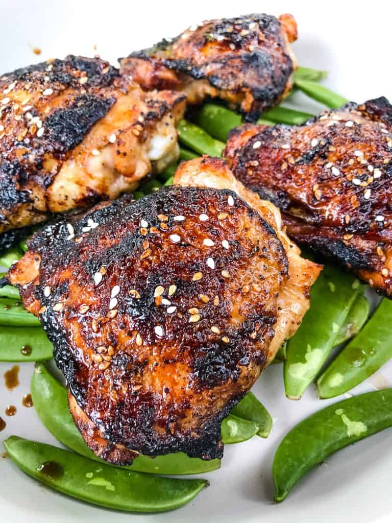Sesame Soy Glazed Grilled Chicken Thighs are an easy grilled chicken recipe. BBQ bone in grilled chicken thighs are coated in a simple Asian glaze sauce. #grilledchickenthighs #glazedchickenrecipes #asianchickenrecipes