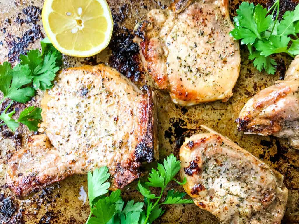 Italian Baked Pork Chops on a baking sheet with herbs