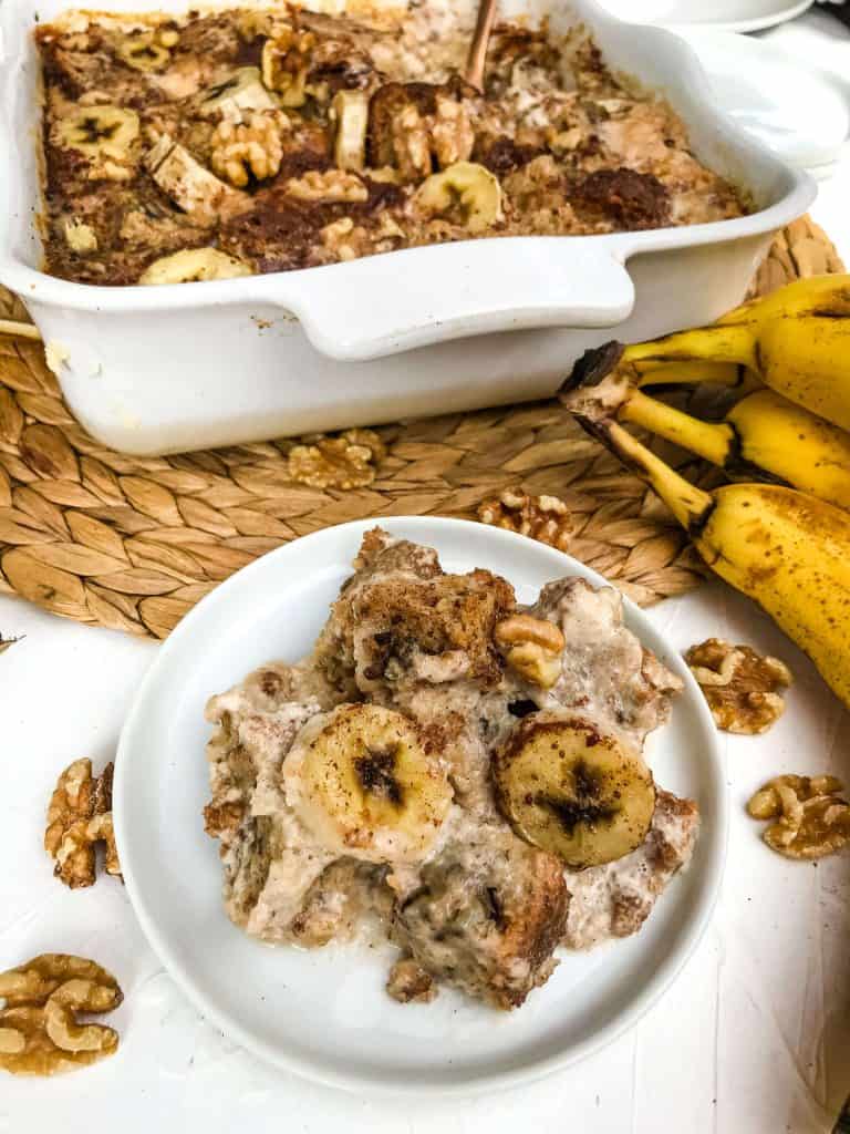 A plate of Banana Bread Pudding next to the serving dish