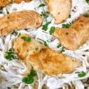 Closer view of chicken on top of Copycat Olive Garden Chicken Fettuccine Alfredo