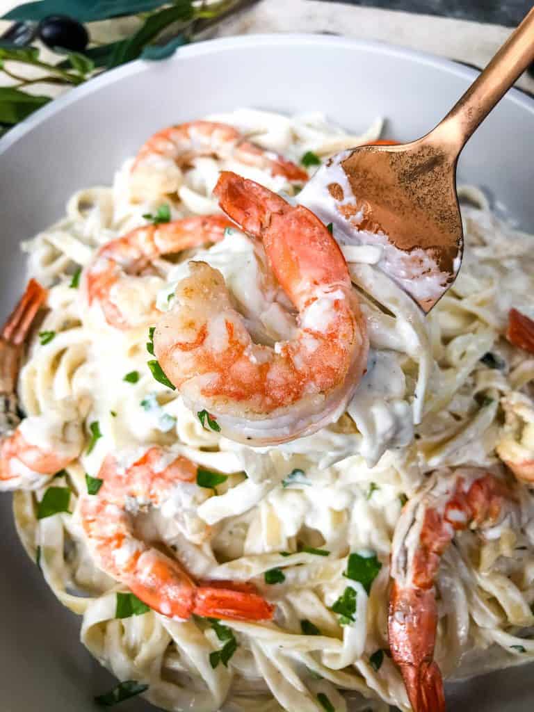 A copper fork serving Copycat Olive Garden Shrimp Alfredo