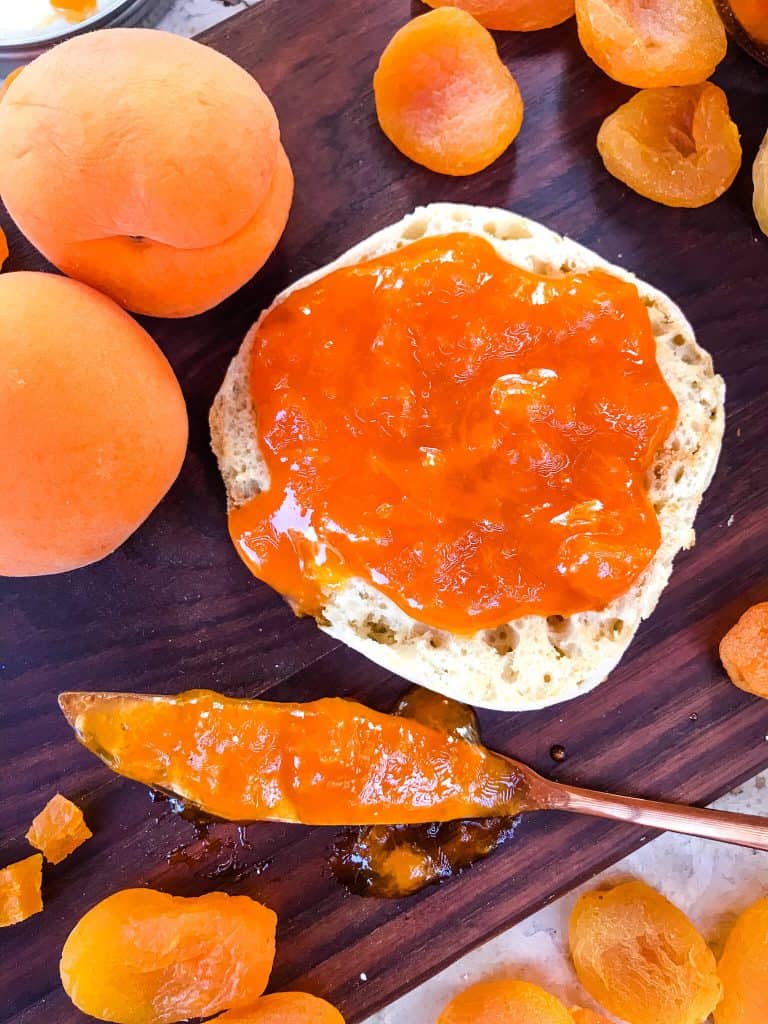 Apricot Jam Recipe spread on an English muffin with a dirty knife