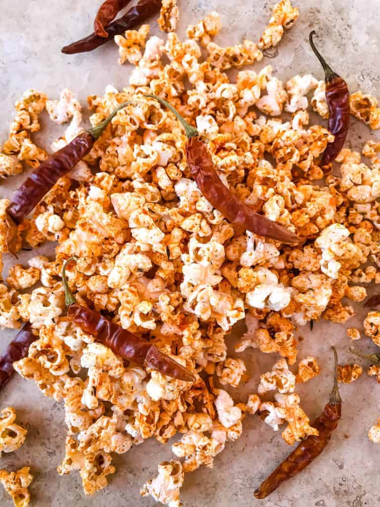 Pile of Homemade Cajun Popcorn with dried peppers on top