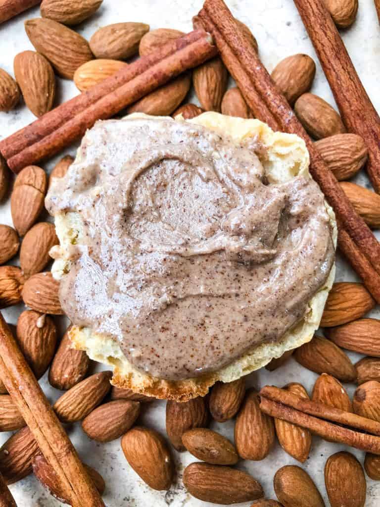 Homemade Cinnamon Almond Butter on a toasted muffin on top of almonds