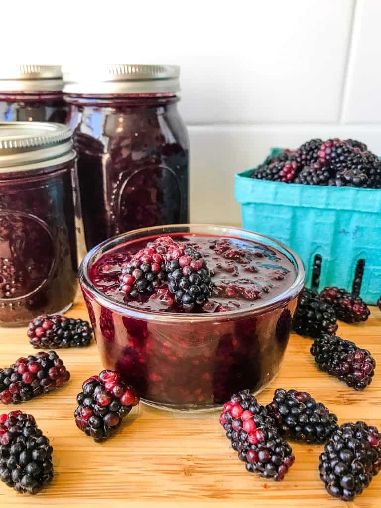 A boel of Homemade Blackberry Jam Recipe (Marionberry Jam) surrounded by berries