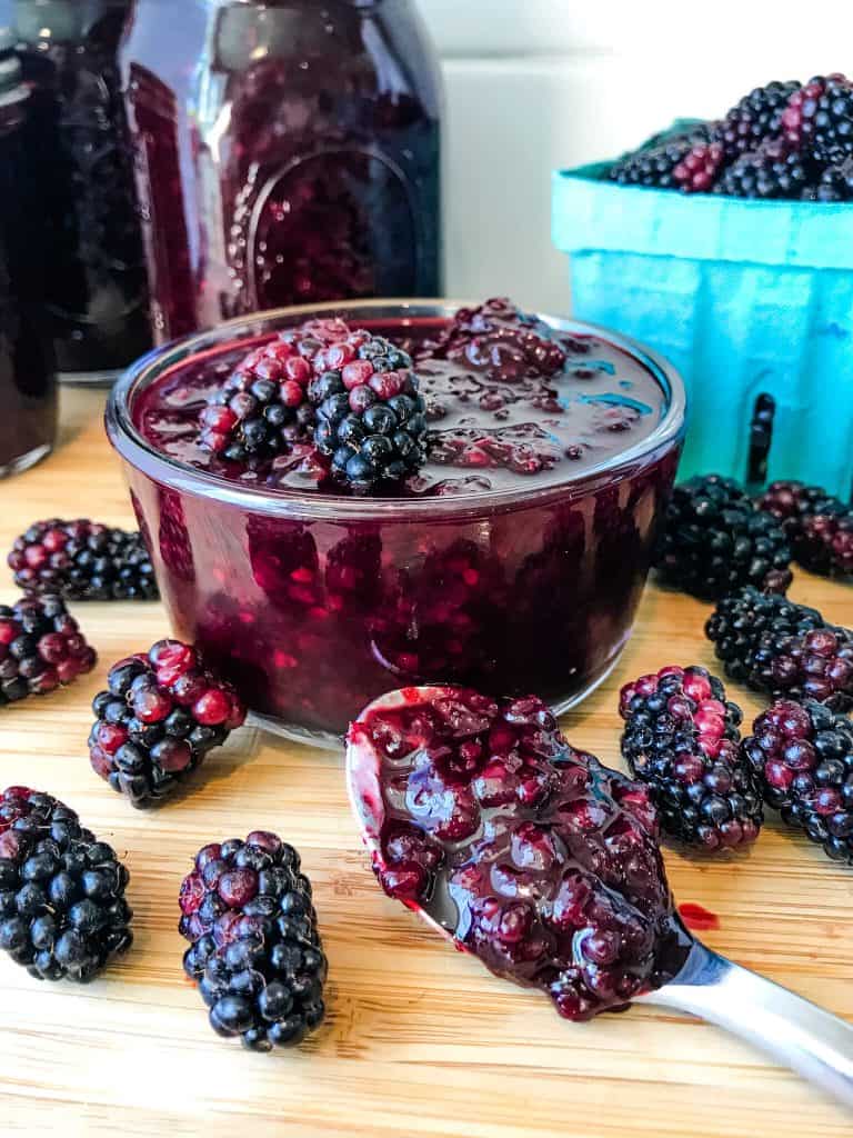 A bowl of Homemade Blackberry Jam Recipe (Marionberry Jam) with a spoon of jam on the side