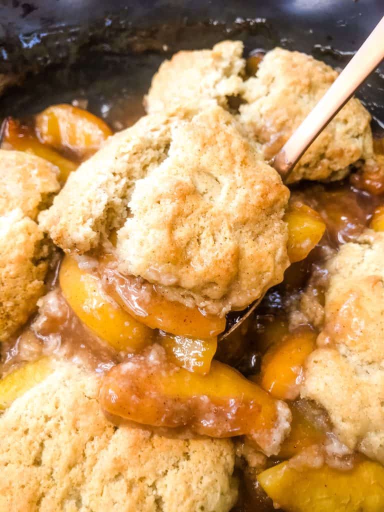 A spoon scooping cobbler out of a dish