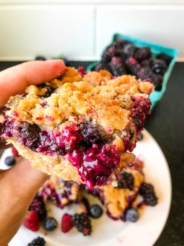 A hand holding a Mixed Berry Crumble Bar