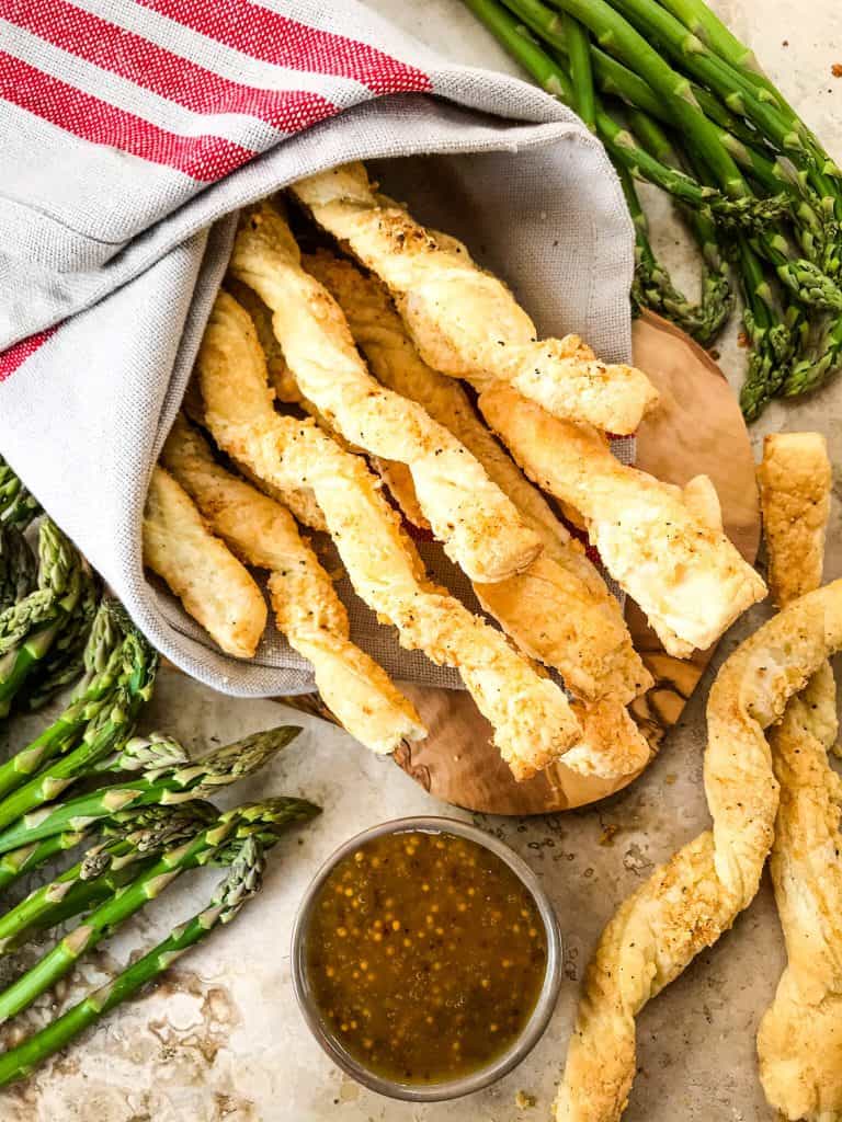 Garlic Parmesan Cheese Straws next to a bowl of honey mustard