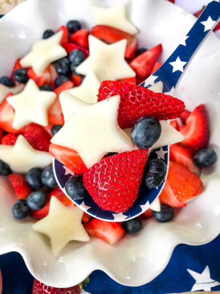 A spoon of Patriotic Red, White, and Blue Fruit Salad