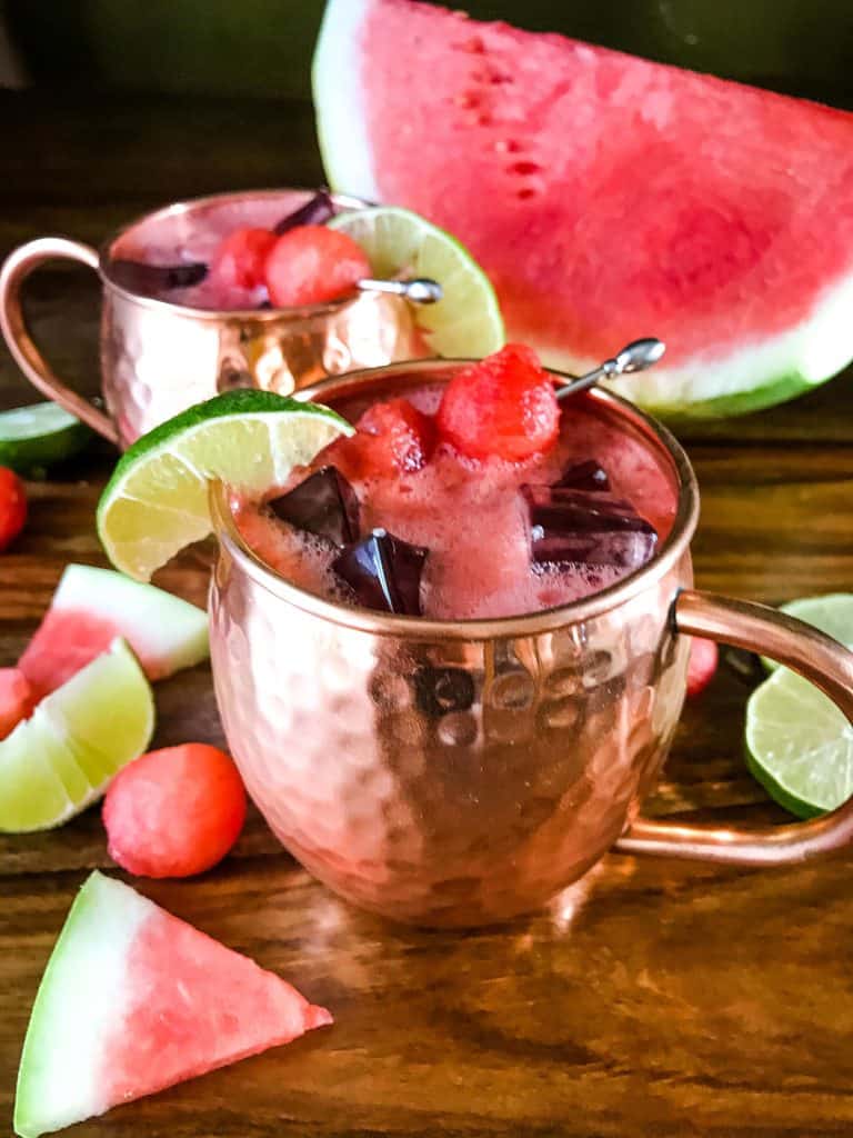 A mug of Watermelon Moscow Mule with watermelon around it