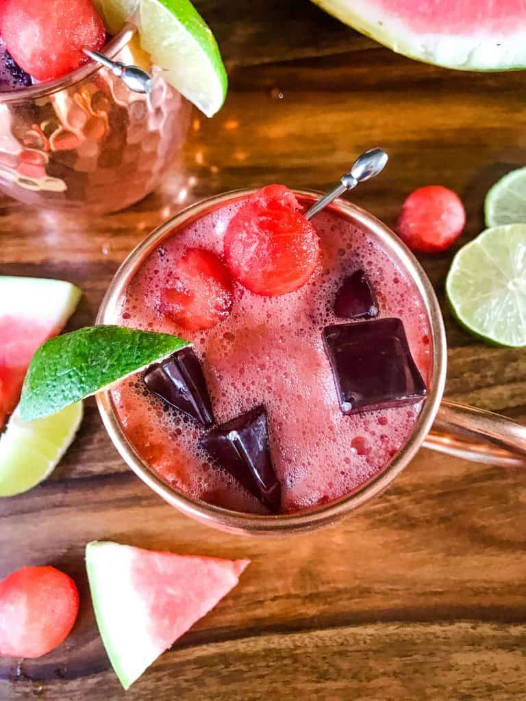 Top view of Watermelon Moscow Mule with limes, watermelon pieces, and watermelon balls around it