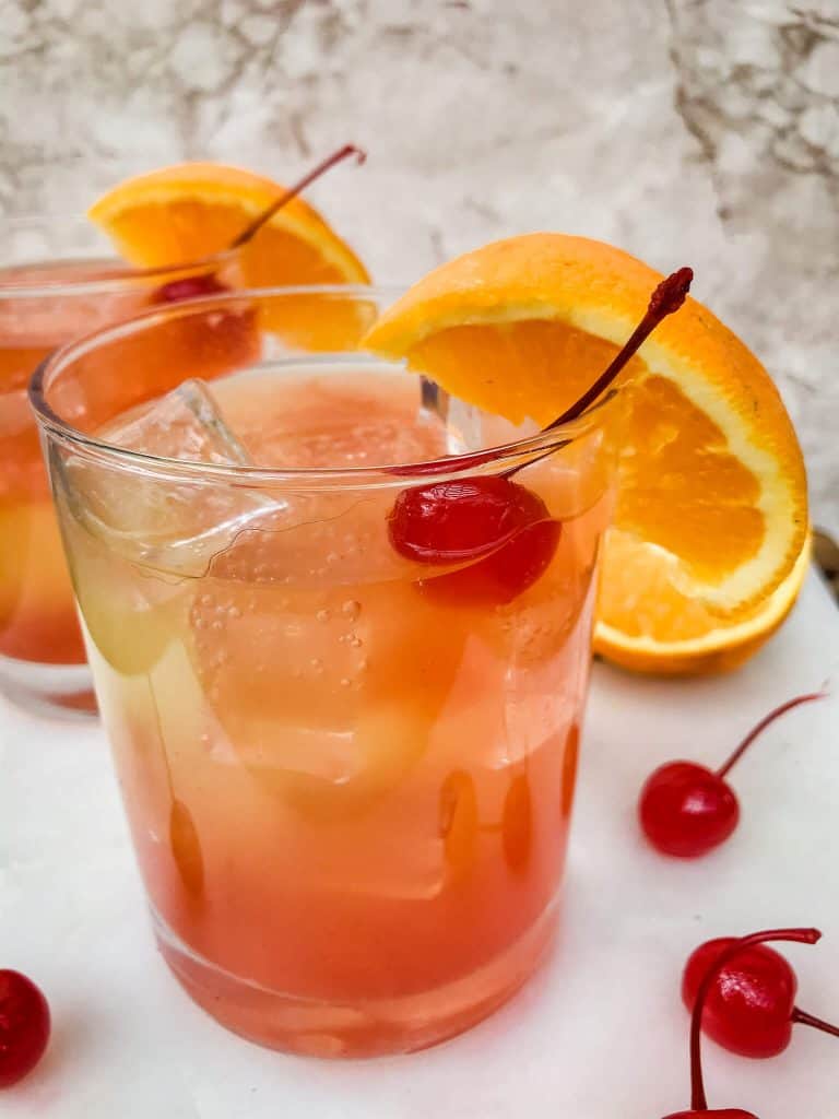 Orange, yellow, and red summer cocktail in a glass