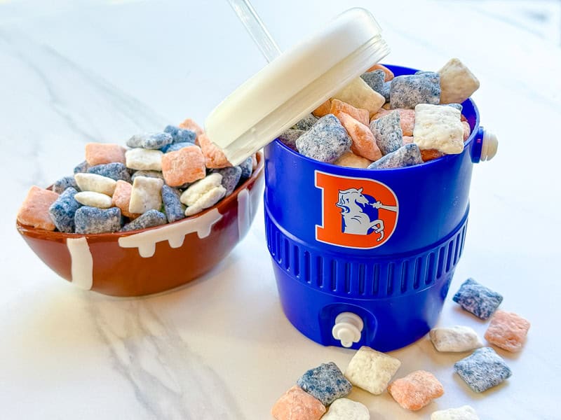 Denver Broncos Puppy Chow in a cooler cup and football bowl on a counter.