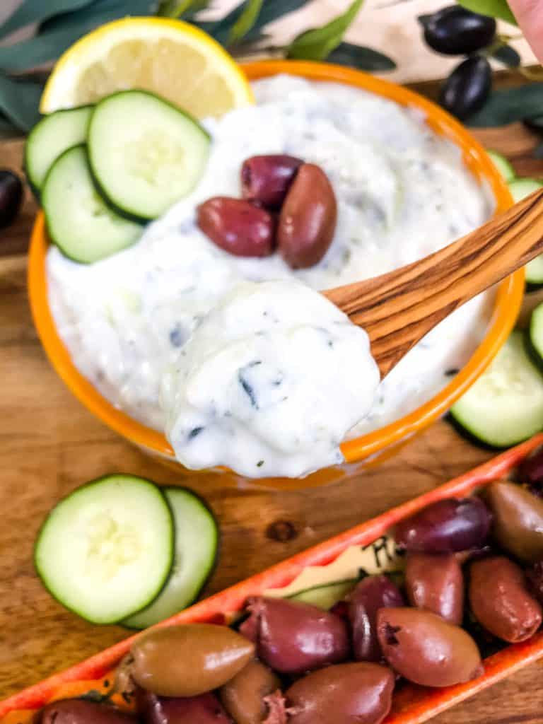 A wood spoon holding Greek Tzatziki Yogurt Sauce