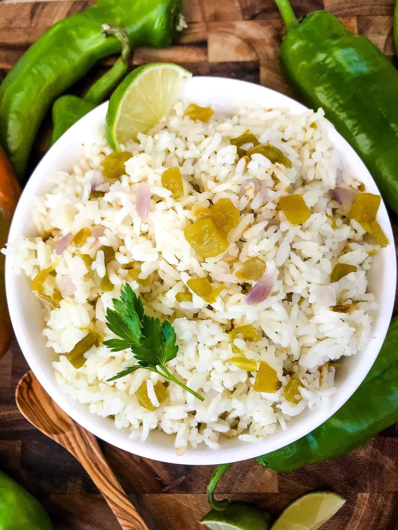 Bowl filled with Hatch Green Chile Rice surrounded by peppers