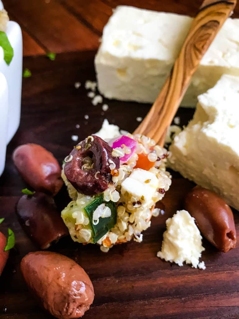 A wood spoon full of Greek Quinoa Salad