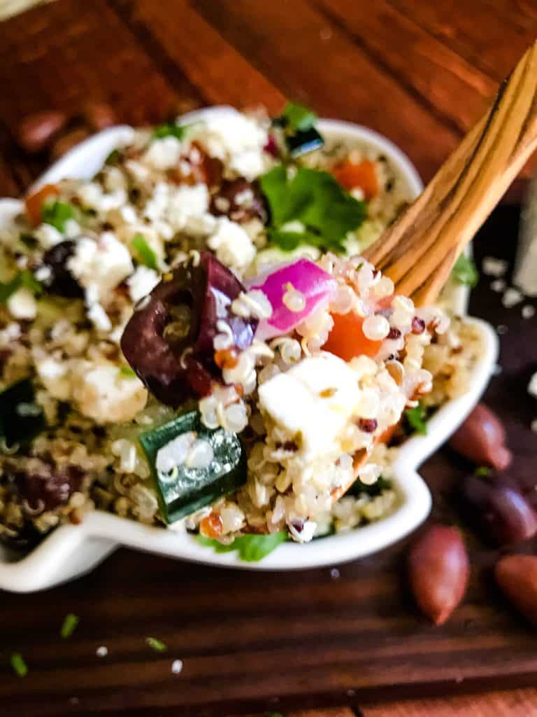 A spoon holding the salad over the bowl