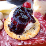 Pin of Plum Jam on a cracker with cheese and title at bottom