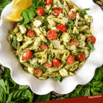 Pin of Pesto Caprese Penne Pasta from the top with lemons in a white dish and title at bottom