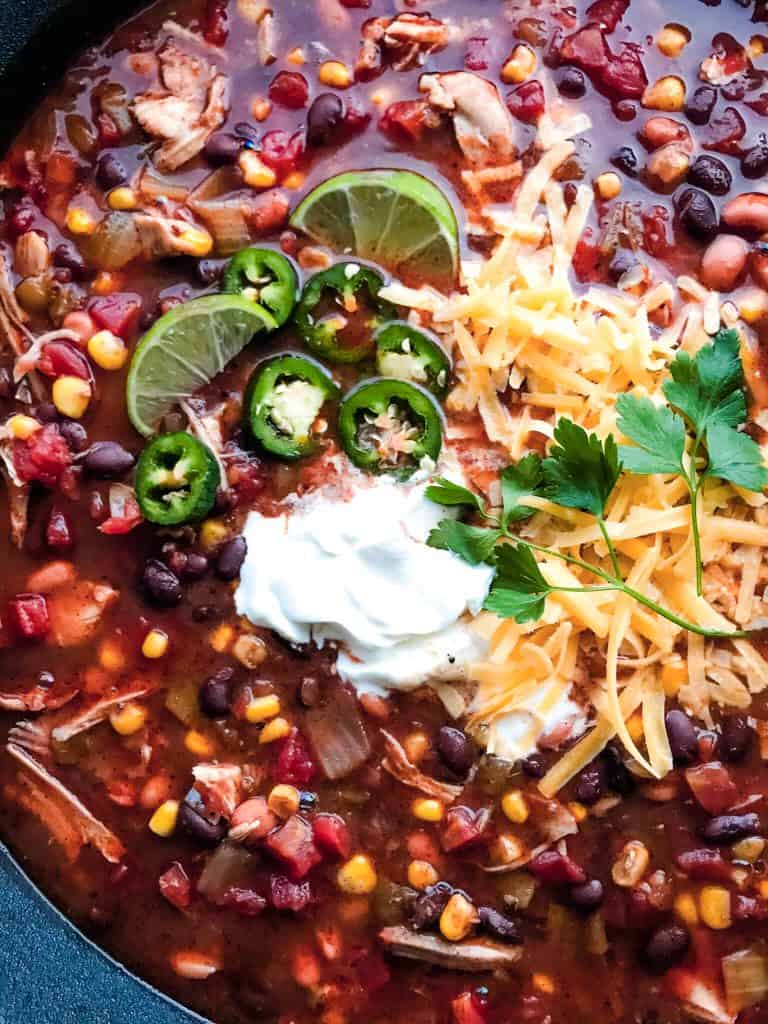 A close up of Chicken Taco Soup featuring beans, corn, chicken, and tomatoes.
