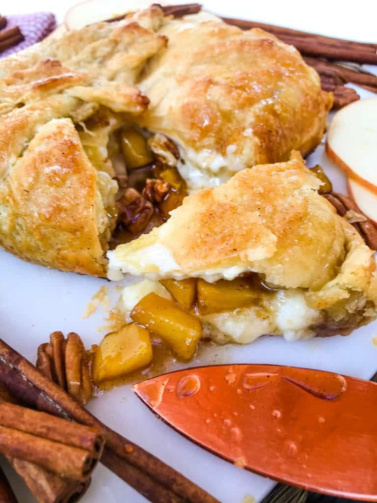 A wedge of Cinnamon Apple Baked Brie in Puff Pastry cut out of the round