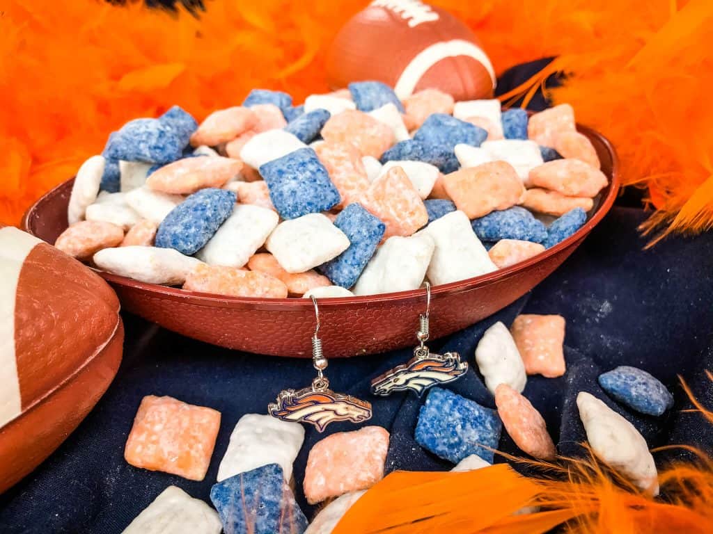 Blue, orange, and white muddy buddies in a football bowl with an orange boa