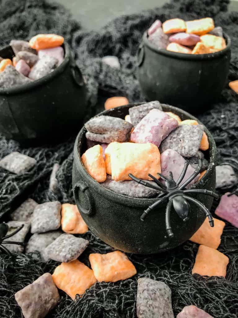 Halloween Puppy Chow in small cauldrons with a spider