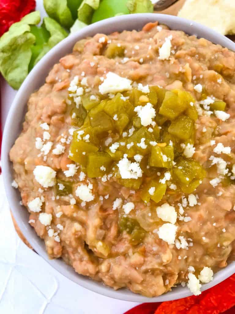 Homemade Hatch Green Chile Refried Beans in a bowl with peppers