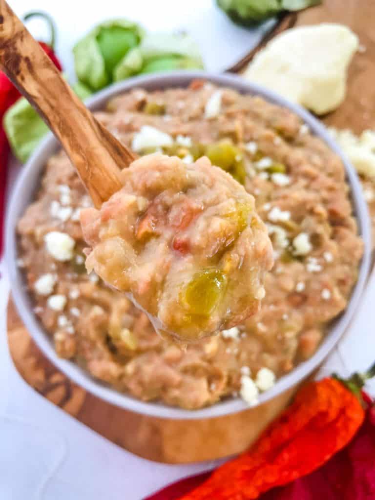 A wood spoon of Homemade Hatch Green Chile Refried Beans