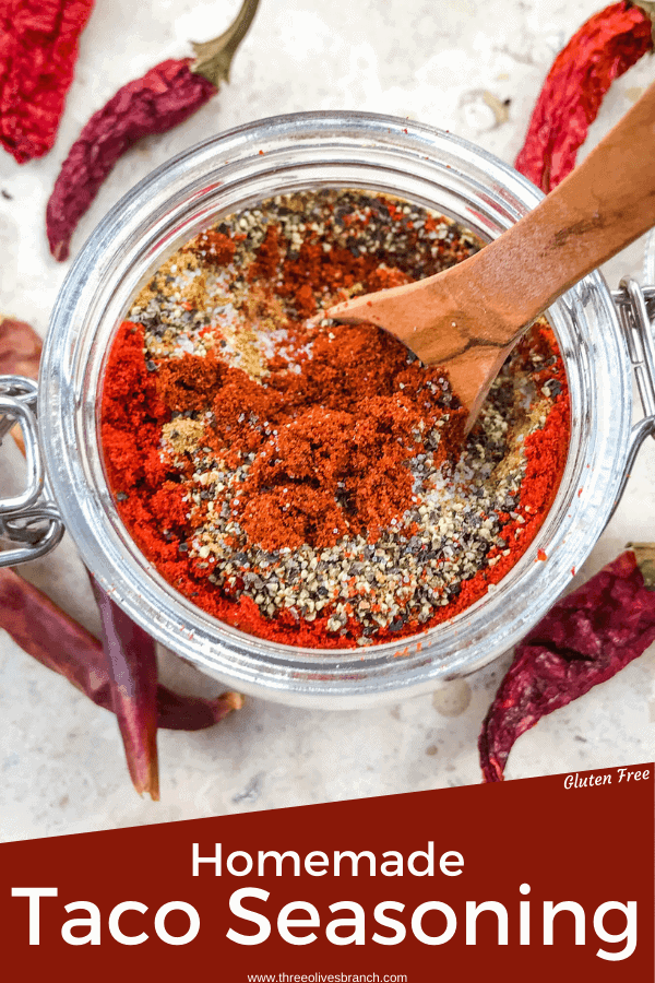 Pin image top view of Homemade Taco Seasoning layered spices with a spoon in it surrounded by peppers with title at bottom