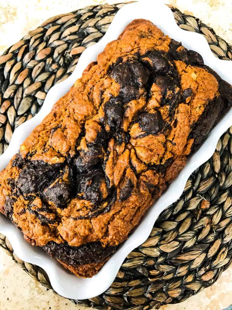 A loaf of Marbled Chocolate Pumpkin Bread in a white dish