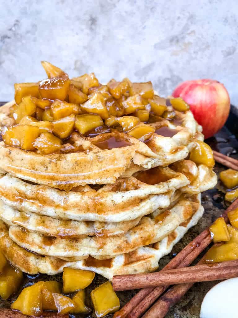 A stack of waffles with apples on top