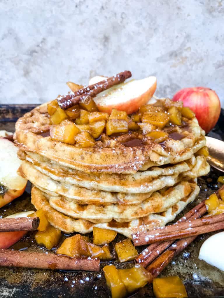 A stack of Cinnamon Apple Waffles with apple sauce