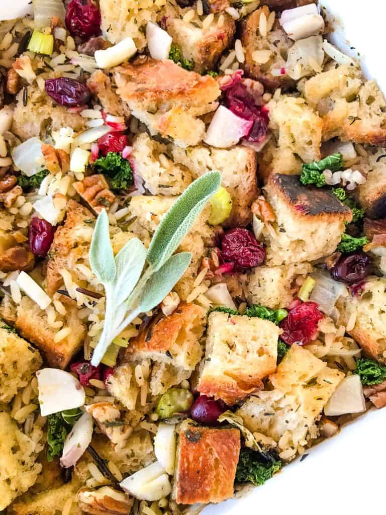 Close up of Thanksgiving Stuffing with Cranberries, Kale, Pecans, and Wild Rice in a white dish