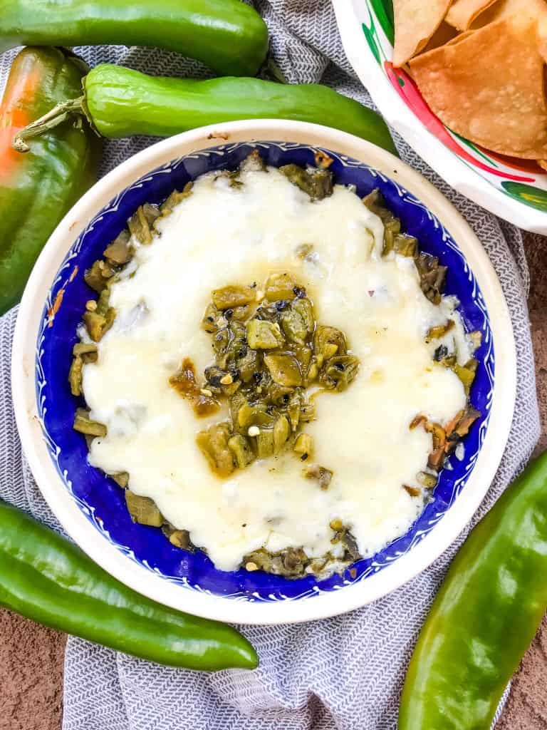 Hatch peppers topped with melted cheese in a dish on top of a towel