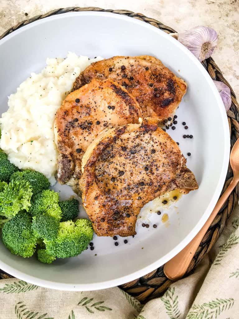 Peppercorn Garlic Pork Chops in a serving dish with sides