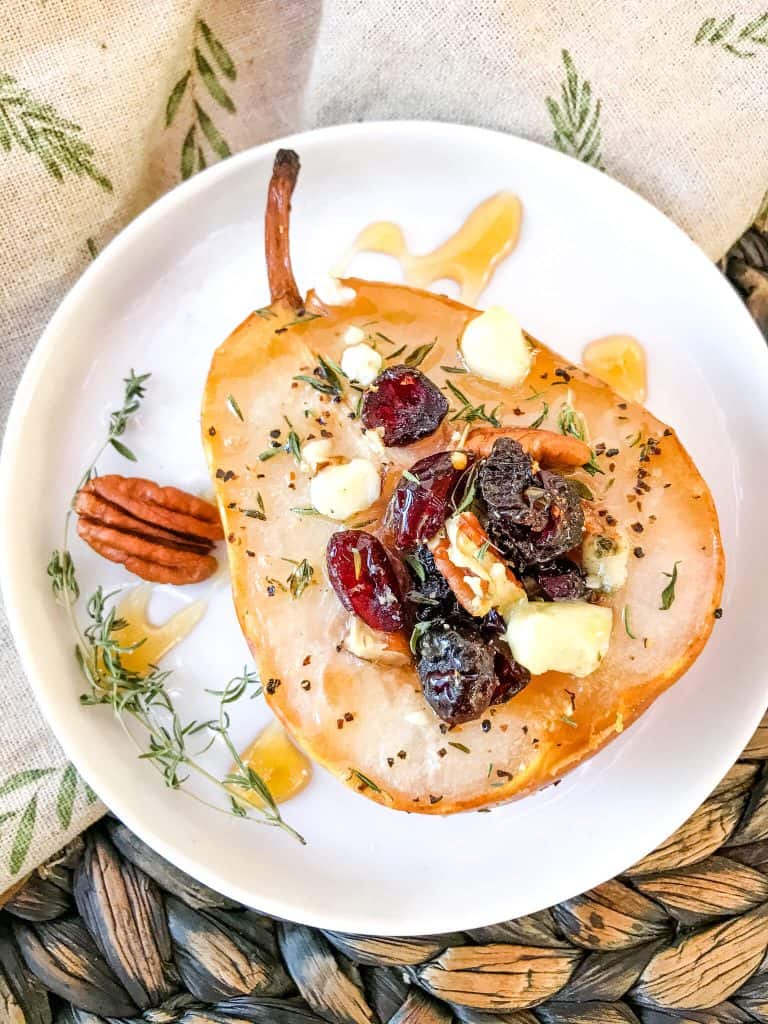 A half of Savory Baked Pears with Gorgonzola, Walnuts, and Cranberries on a small plate